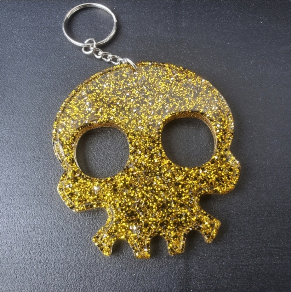 Self defense skull key chain with gold, black and silver glitter.
